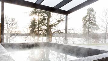 Relax in a serene hot tub surrounded by a tranquil landscape view.
