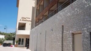 Een hotel met een gevel van steen, balkons en een bord met de tekst 'Hotel A Madonetta'.