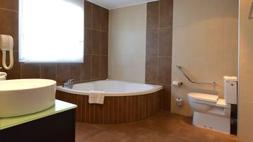 Ein modernes Badezimmer mit freistehender Badewanne, Toilette und Waschbecken.