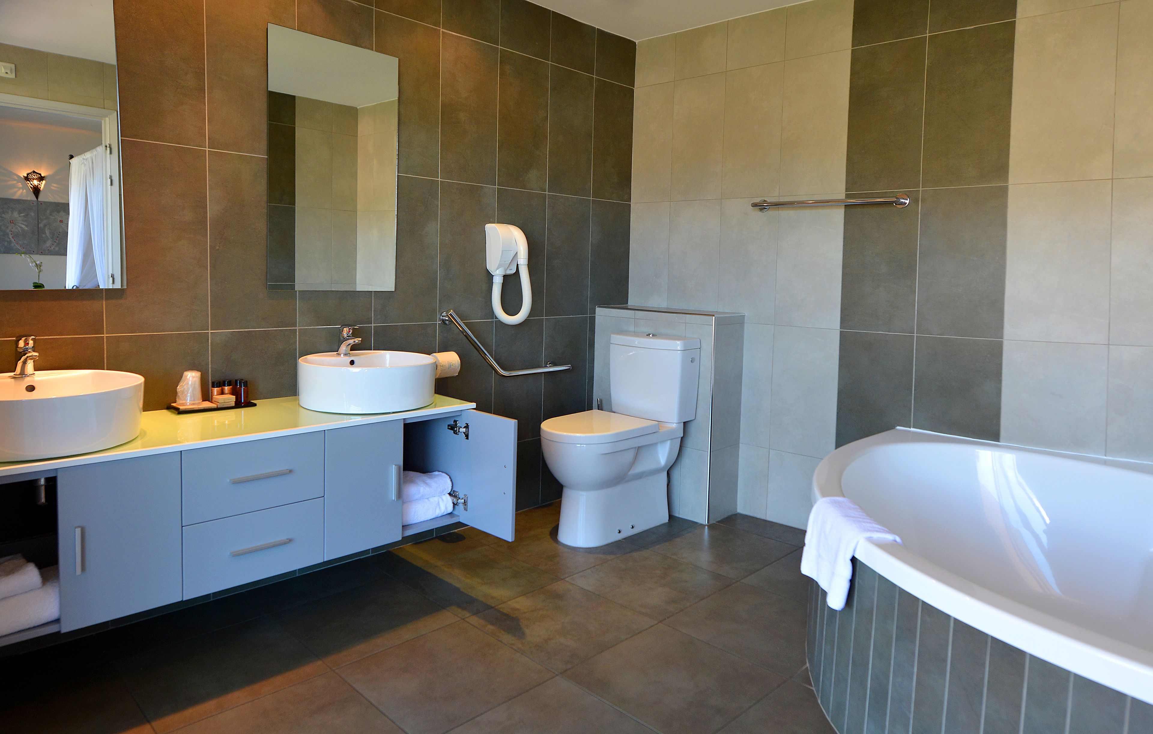 A modern bathroom with a sink, toilet, and bathtub.