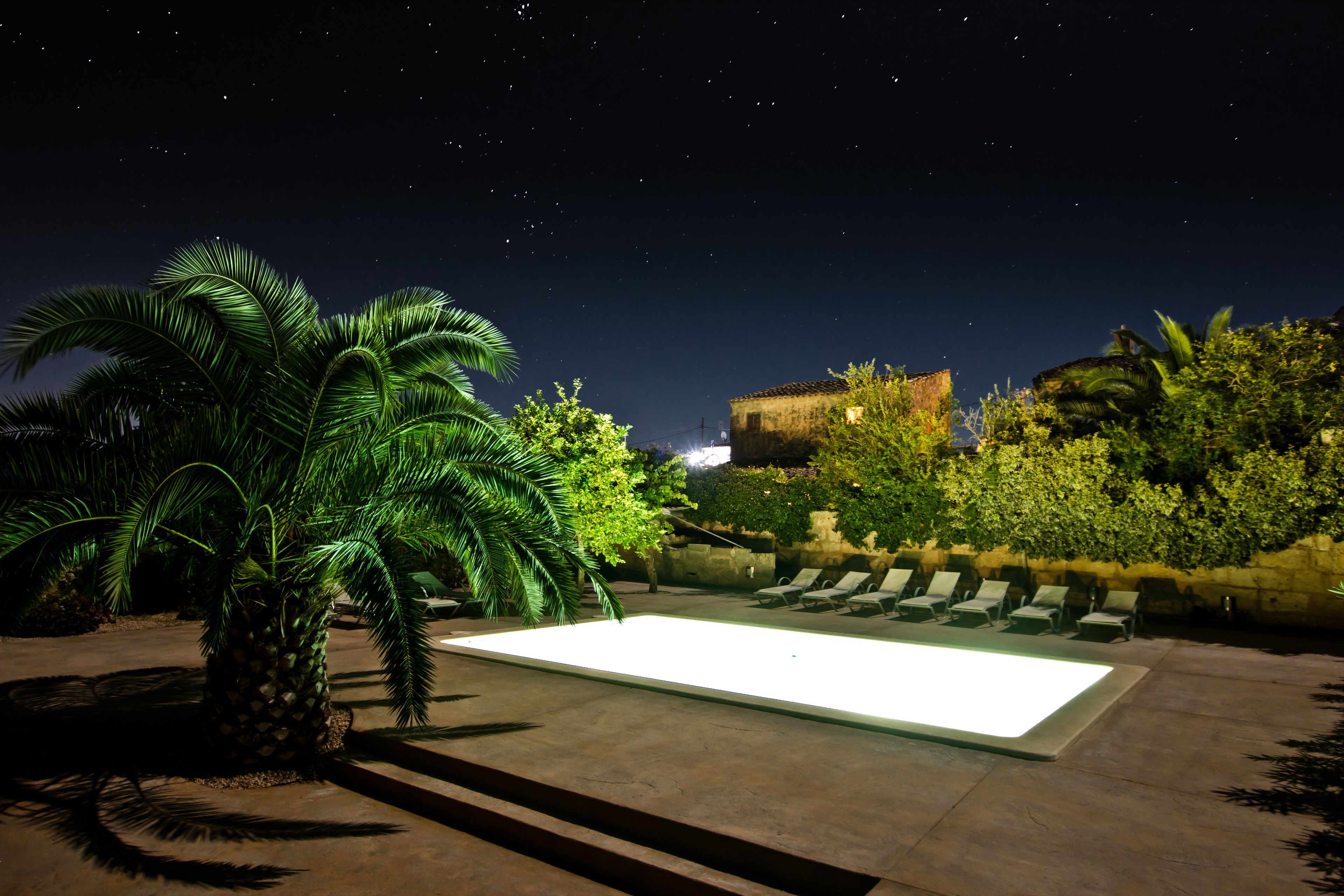 Una piscina al aire libre, sombrillas, tumbonas