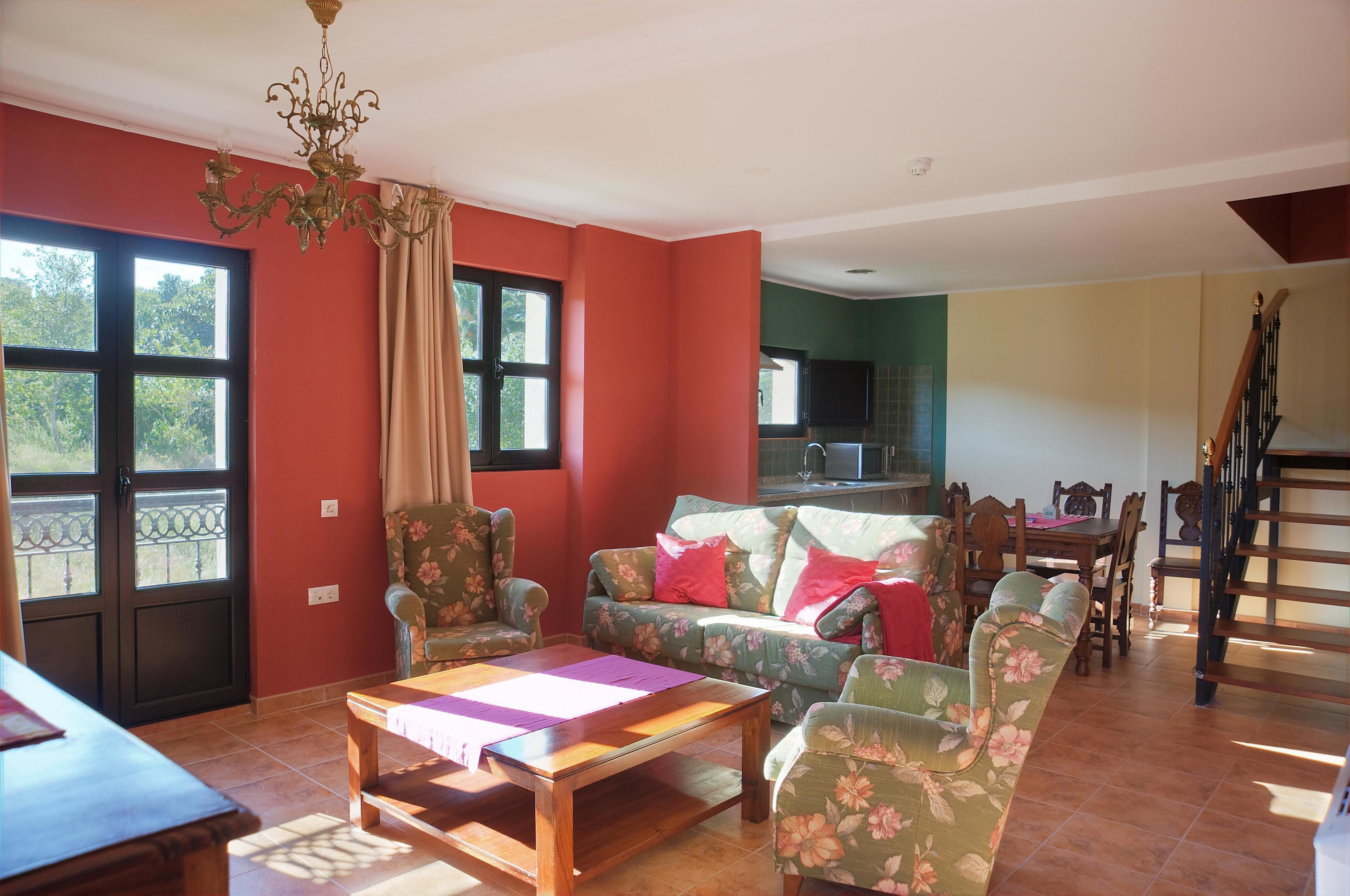 A living room with a sofa, armchairs, a coffee table, and a dining area with a table and chairs.