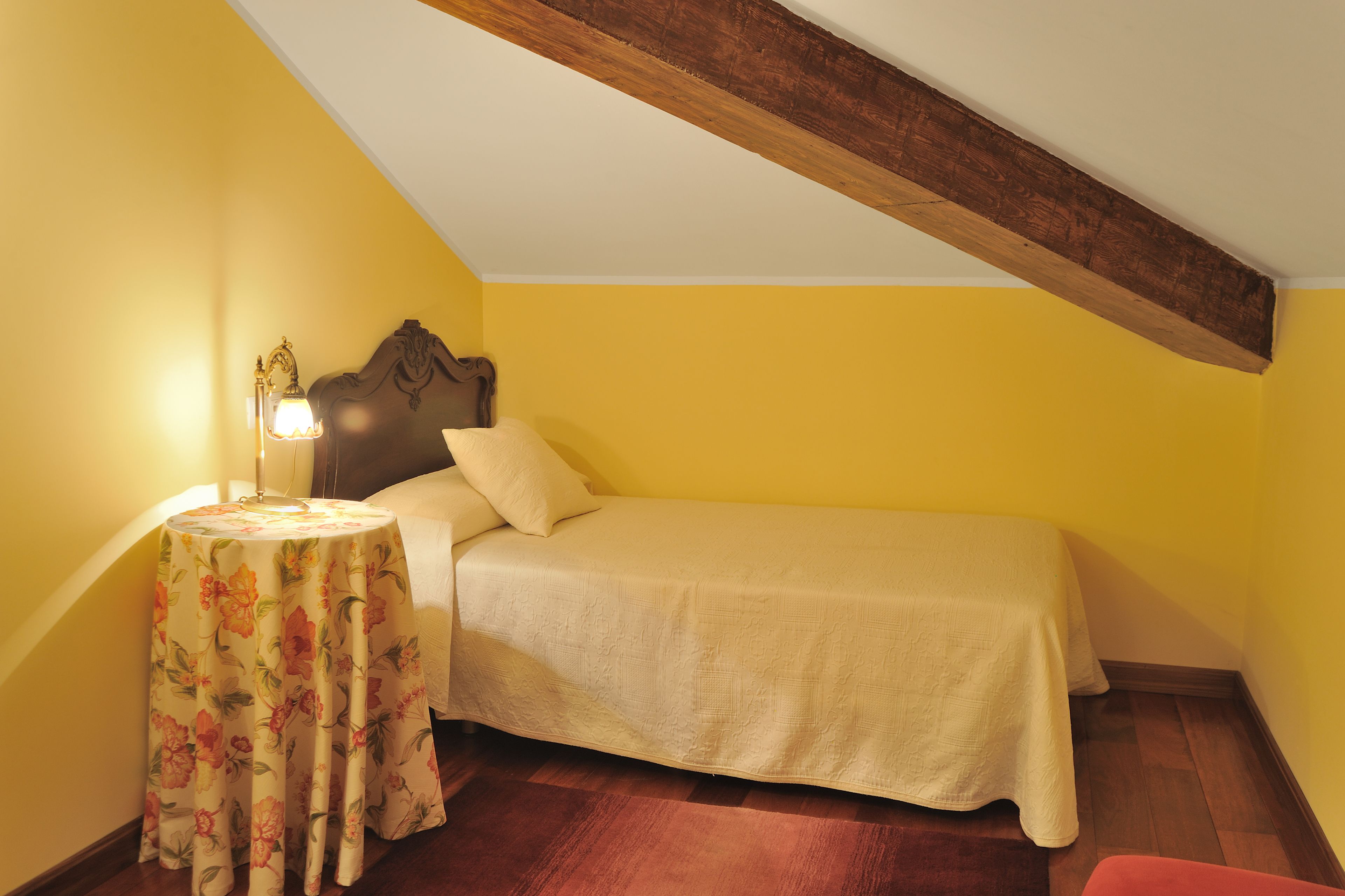 Une chambre à coucher avec un lit, une table de chevet et une lampe.
