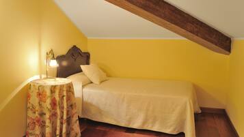 Un dormitorio con una cama, una mesita de noche y una lámpara.