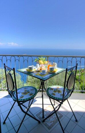 Una mesa con alimentos para el desayuno y vista al mar.