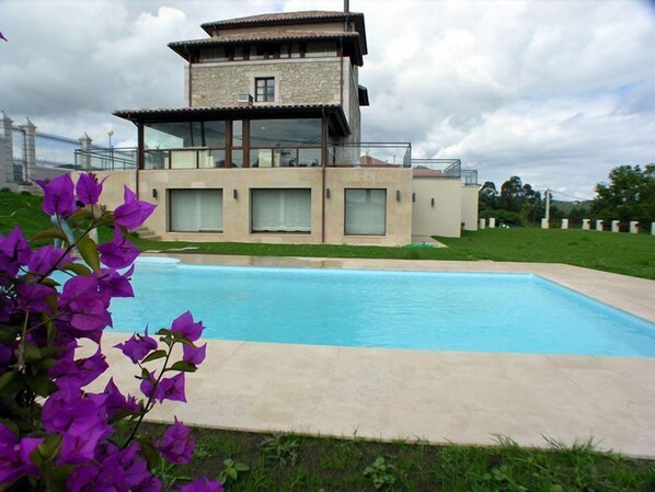 Un edificio moderno de dos pisos con piscina delantera.
