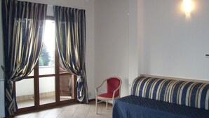 A room with a sofa, a chair, and a window with curtains. - Villa Giovanna (Somma Lombardo)