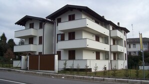 A multi-story residential building with balconies, a gated entrance, and a small garden area. - Villa Giovanna (Somma Lombardo)