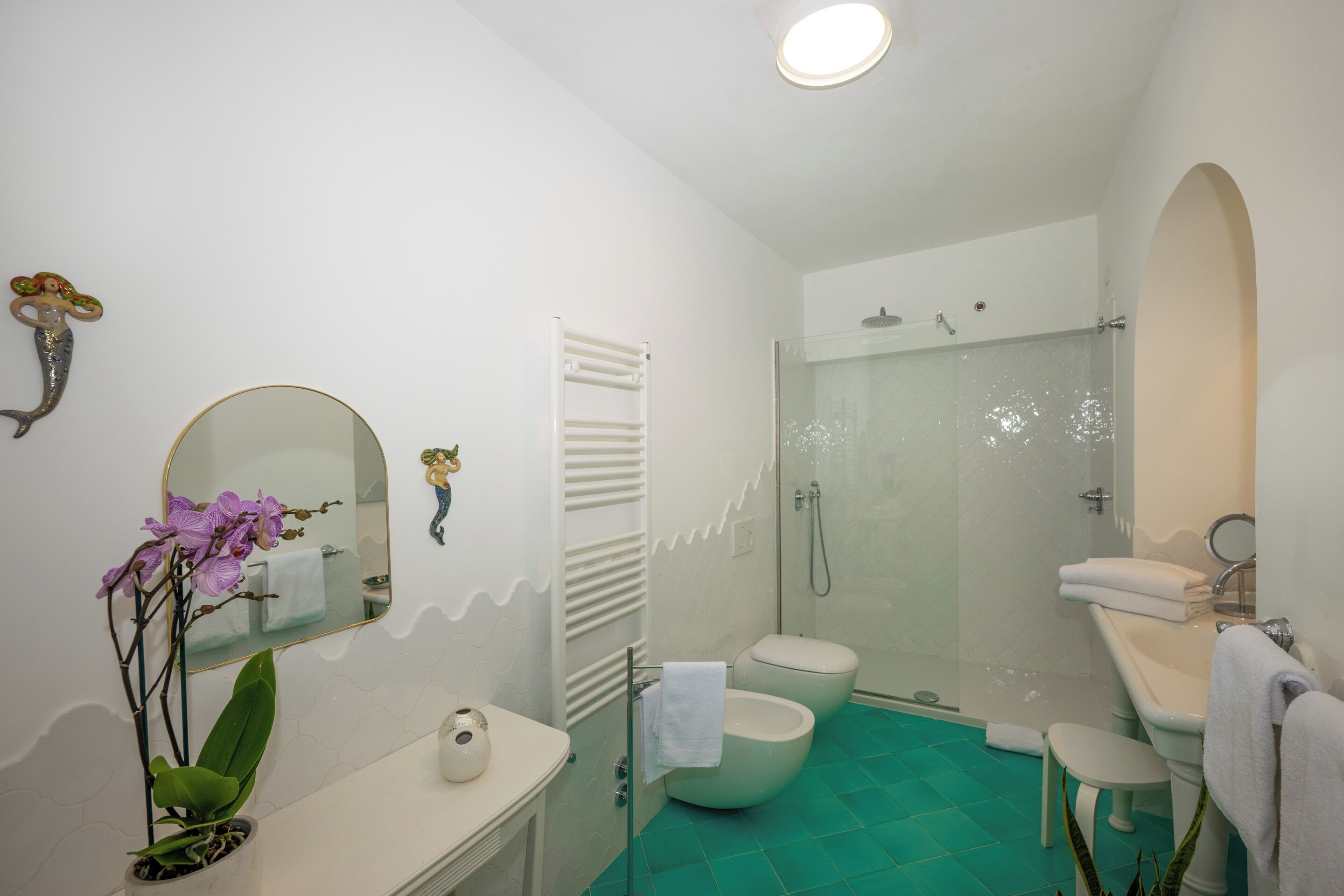 Un baño con inodoro, lavamanos, ducha y espejo.