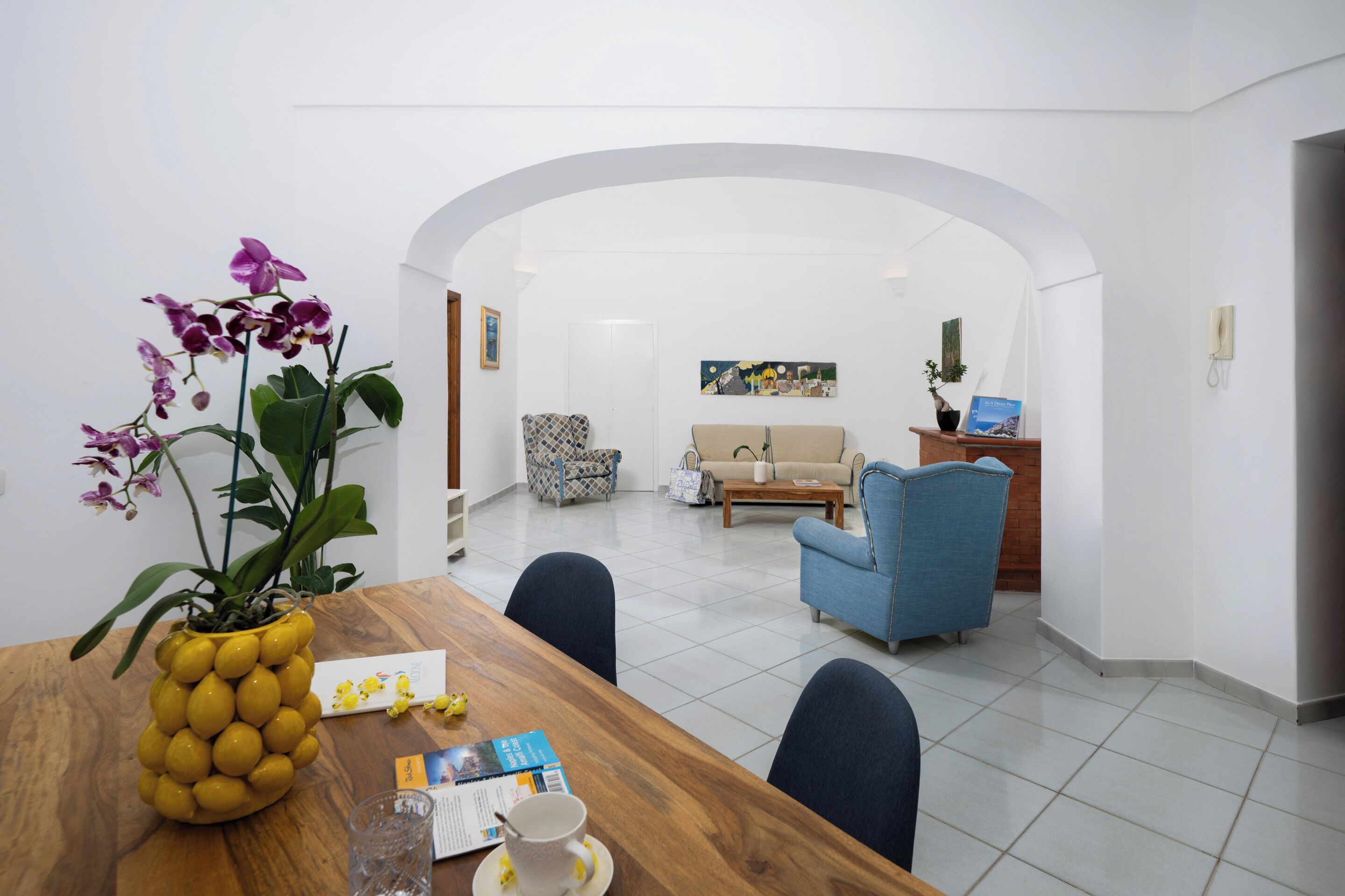 Ein modernes Wohnzimmer mit einer Couch, Sesseln und einem Couchtisch.