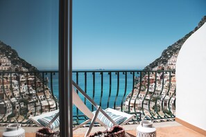 A balcony with a view of the sea and a coastal town.