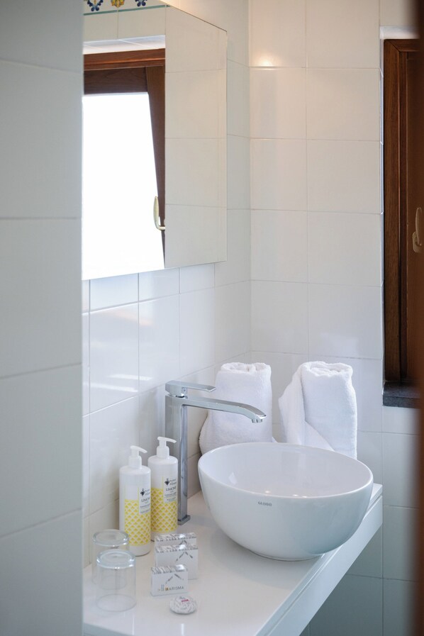 A bathroom with a white sink, a mirror, and two towels.