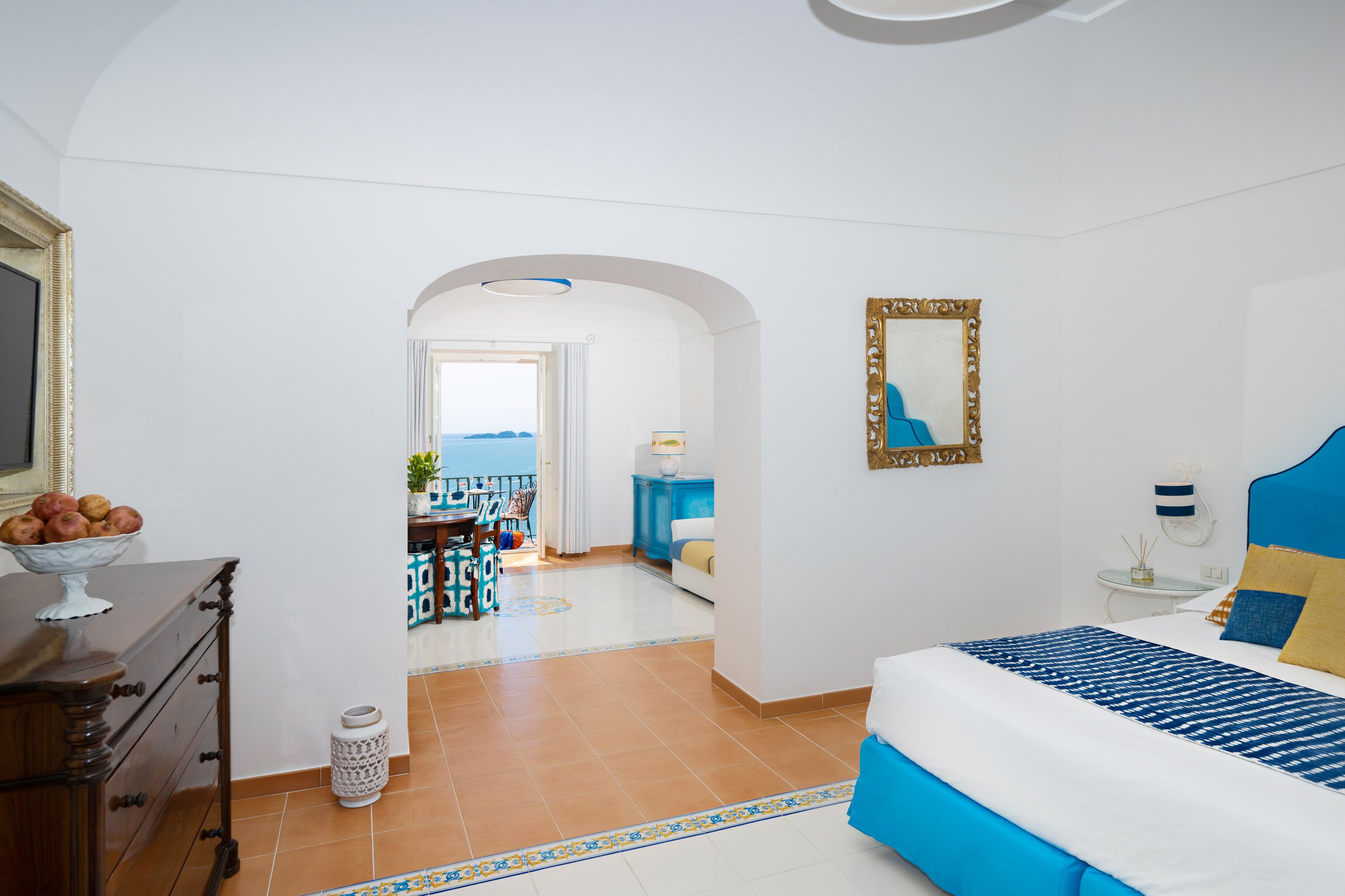 Habitación de hotel con cama, cómoda y vista al mar.