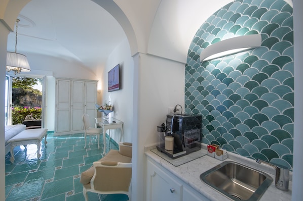 A modern bathroom with a tiled floor, a sink, and a coffee machine. - Hotel Pellegrino (Praiano)