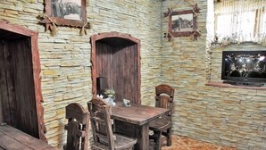 Una habitació rústica amb parets de pedra, mobles de fusta i una televisió.