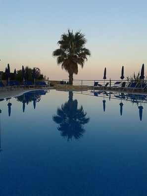 季節性室外游泳池，提供泳池遮陽傘和日光浴躺椅