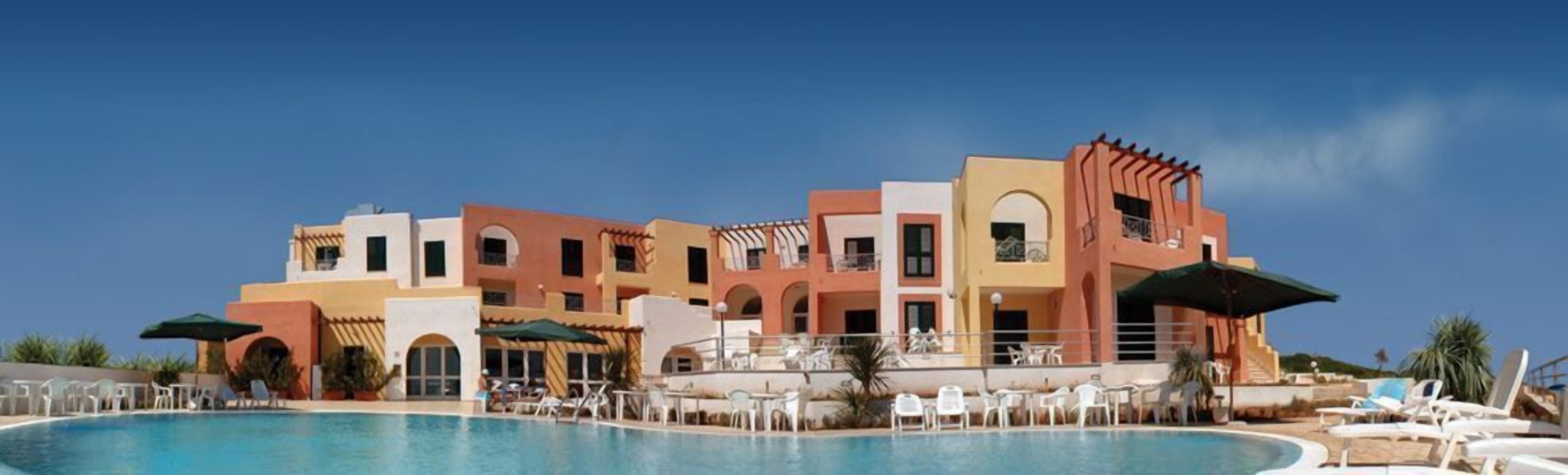 Un complexe hôtelier doté d’une piscine, de nombreux balcons et d’espaces extérieurs aménagés pour se détendre.