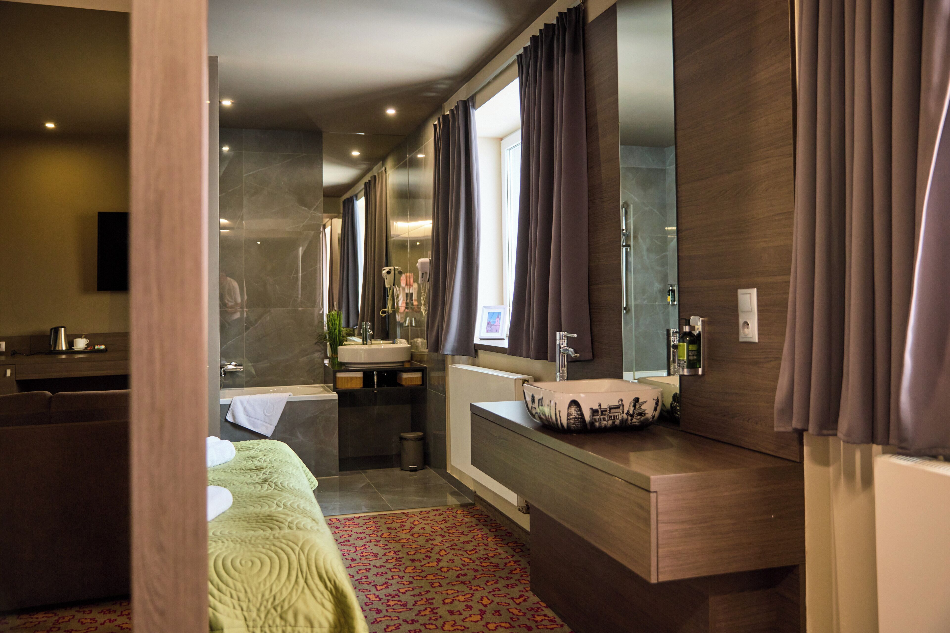 A modern bathroom with a bathtub, a sink, and a mirror.