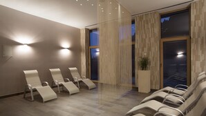 A modern waiting area with reclining chairs, a large window, and a decorative wall panel. - Wellness Hotel Montis (Mozirje)
