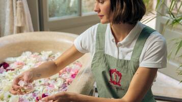 A person arranging flowers in a large, shallow container.