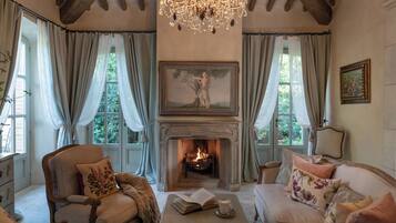 Una habitación acogedora con chimenea, un candelabro y asientos cómodos.