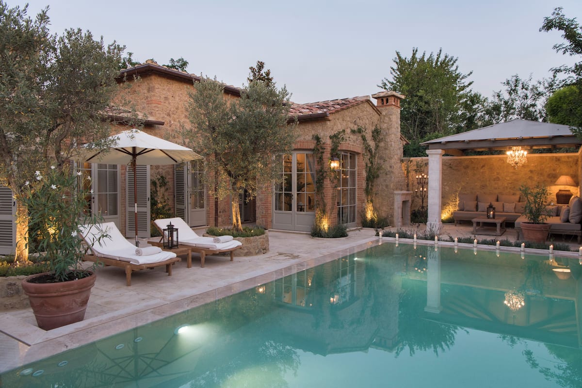 A pool area with lounge chairs and a pergola.