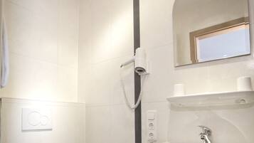 A modern bathroom with a toilet, sink, and shower.
