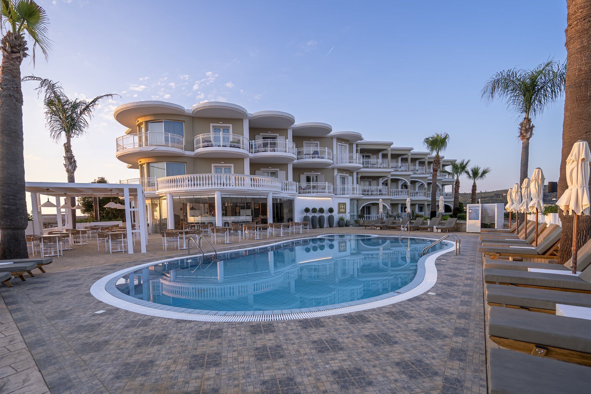 Un hôtel doté d’une piscine, de nombreux balcons et d’espaces extérieurs aménagés pour se détendre.