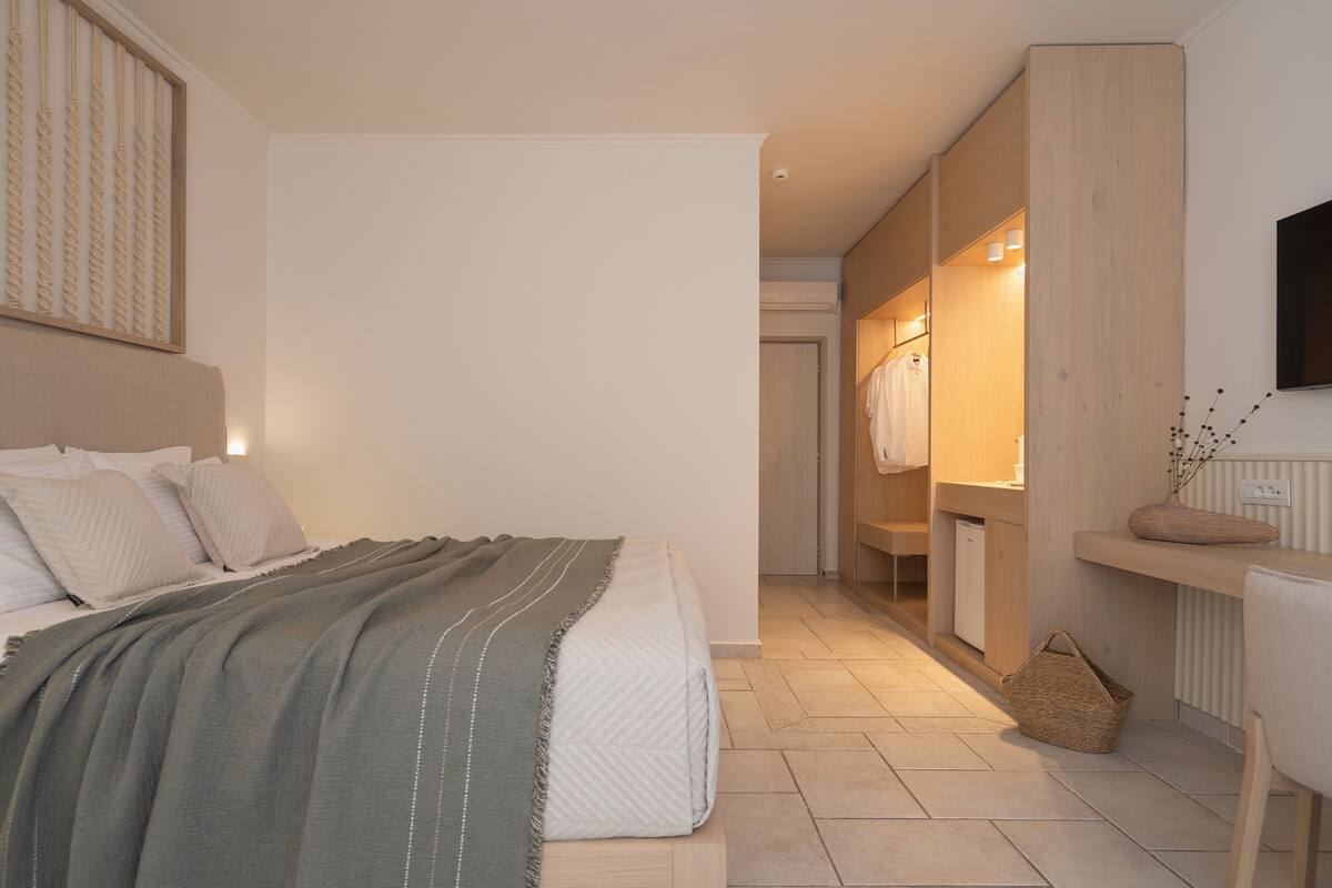 Un dormitorio con cama, mesita de noche y espejo.