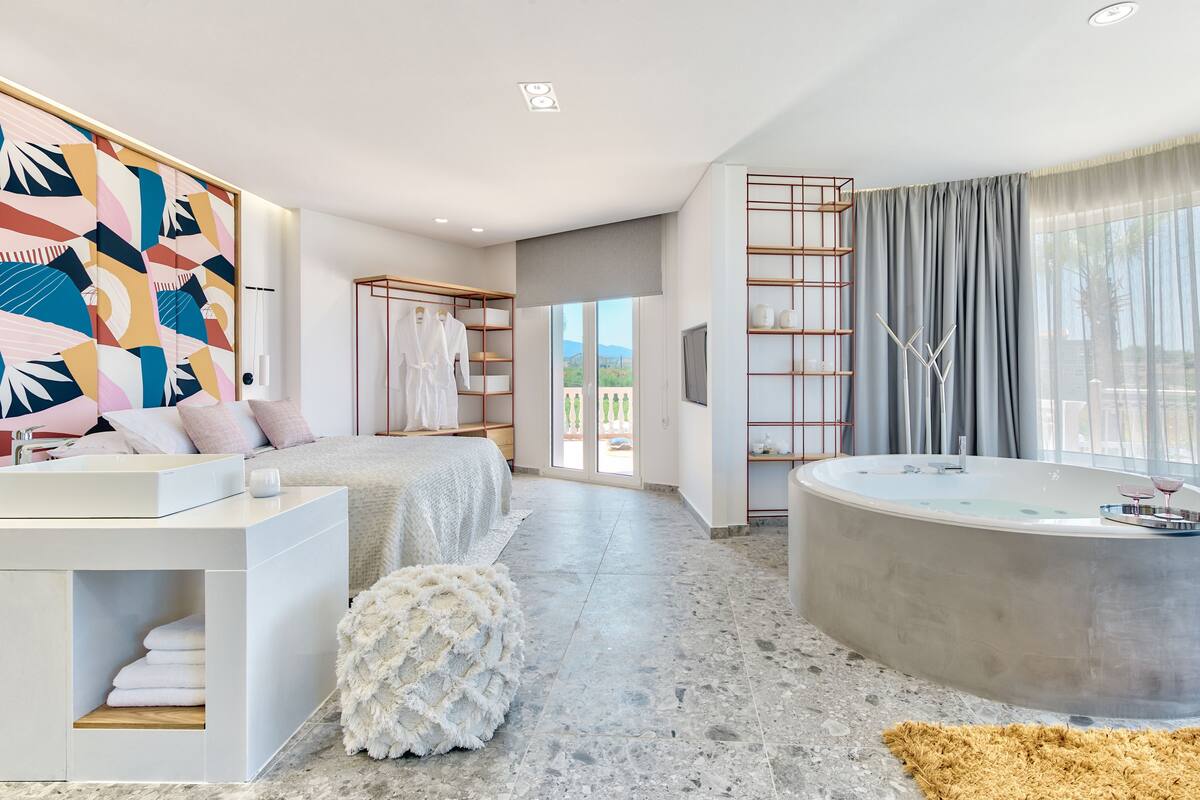 Un baño moderno con una bañera independiente, un tocador con lavamanos y un espejo grande.