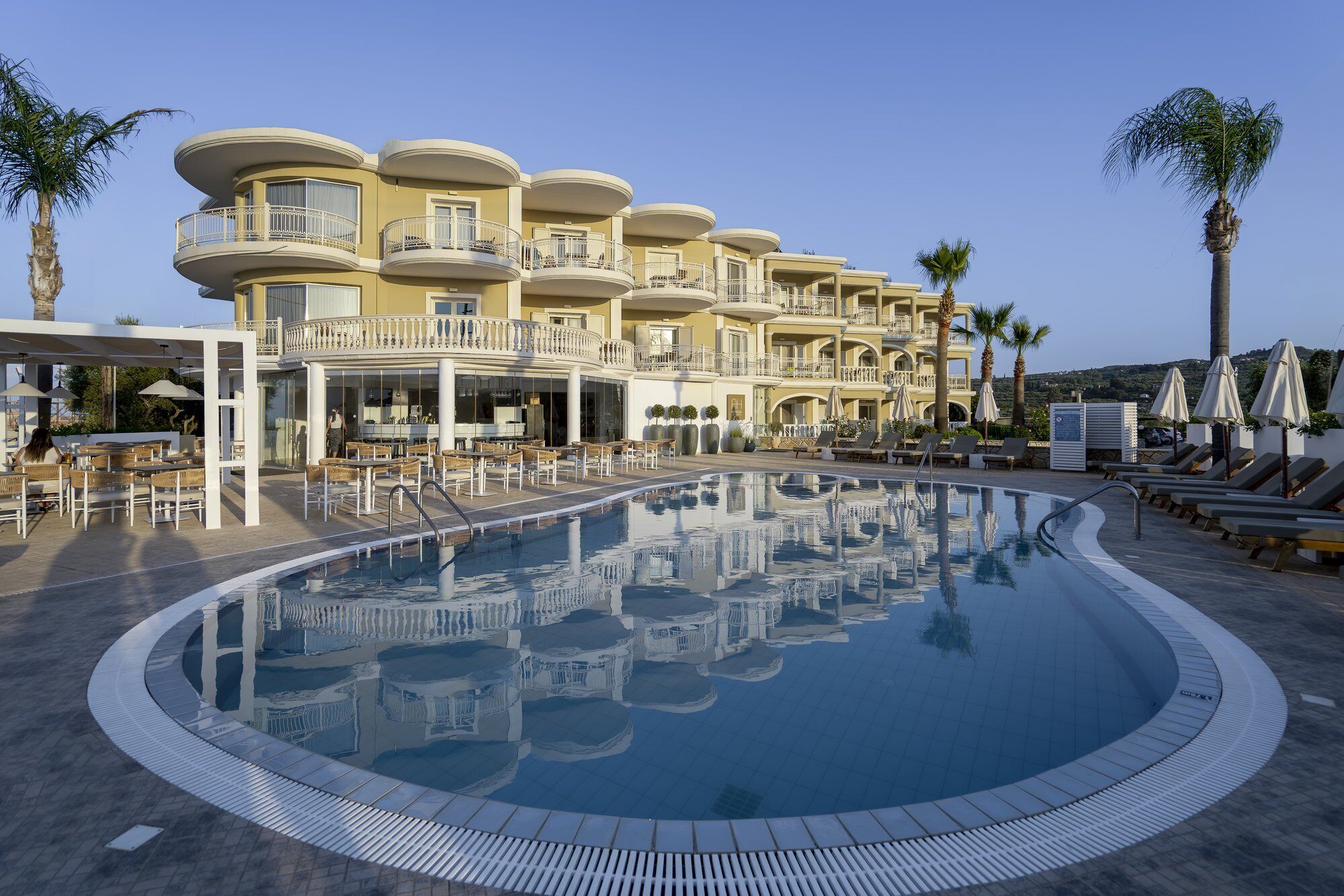 A resort with a large pool, outdoor seating, and multiple balconies.