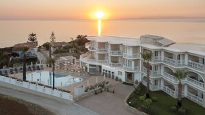 A resort with a pool, multiple balconies, and a sunset view. - Arkadia Luxury Hotel Apartments (Zakynthos)