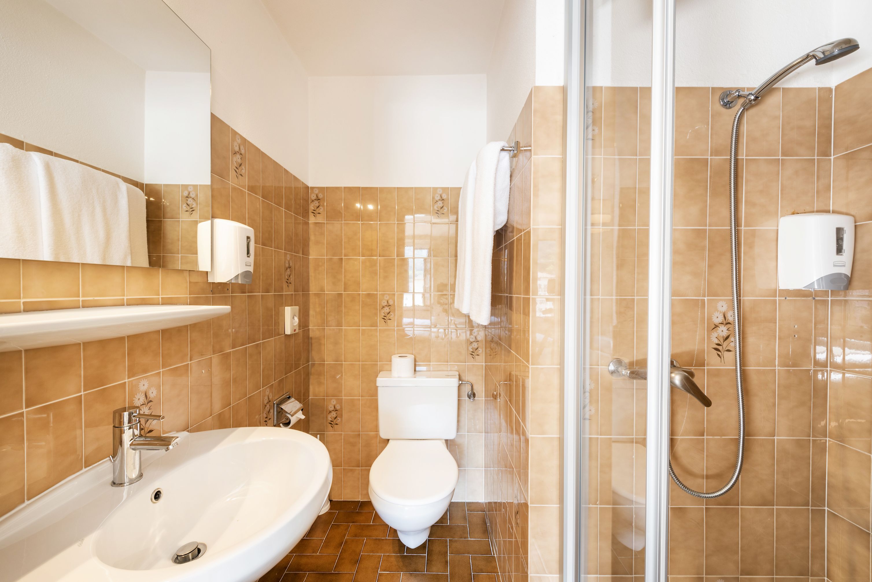 Een badkamer met een wastafel, toilet en douche.