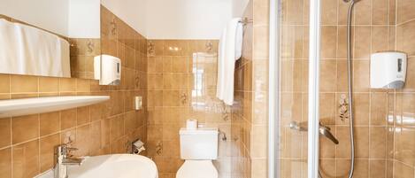 Ein Badezimmer mit Waschbecken, Toilette und Dusche.