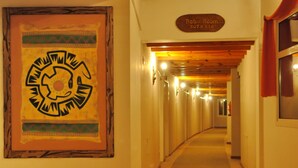 A hallway with a sign reading "Hab/Room 207a 218" and a large wall decoration. - Aikendor Hotel Panorámico (El Calafate)