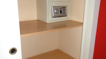 Una habitación con una caja fuerte blanca en la repisa superior y una puerta con pomo redondeado.