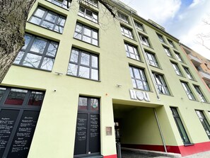 A multi-story building with a green facade, multiple windows, and a visible entrance. - HOLI City Apart Hotel Berlin (Berlin)