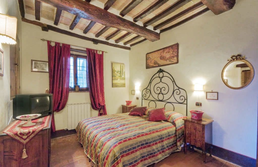 Un dormitorio con cama, cómoda, espejo y ventana con cortinas.