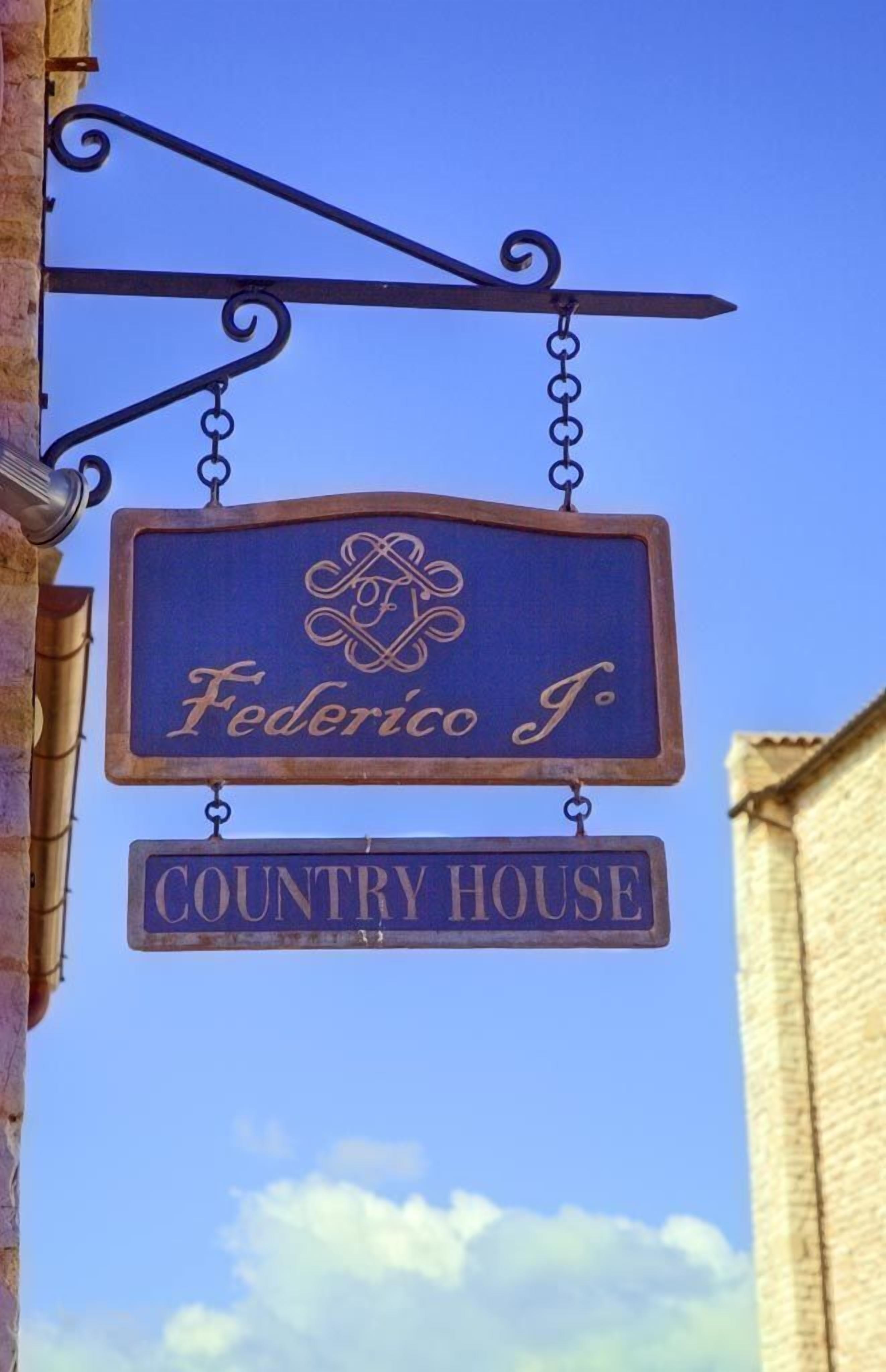 Une enseigne suspendue portant les inscriptions « Federico J. » et « Country House », indiquant le nom d’une propriété.