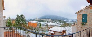 Schneebedeckte Landschaft mit Gebäuden und einem Berg im Hintergrund.