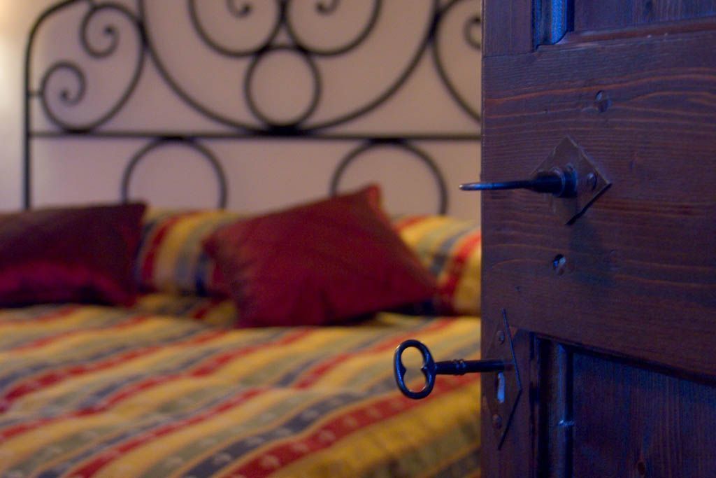 Un lit avec une couvre-lit à rayures et une tête de lit en métal.
