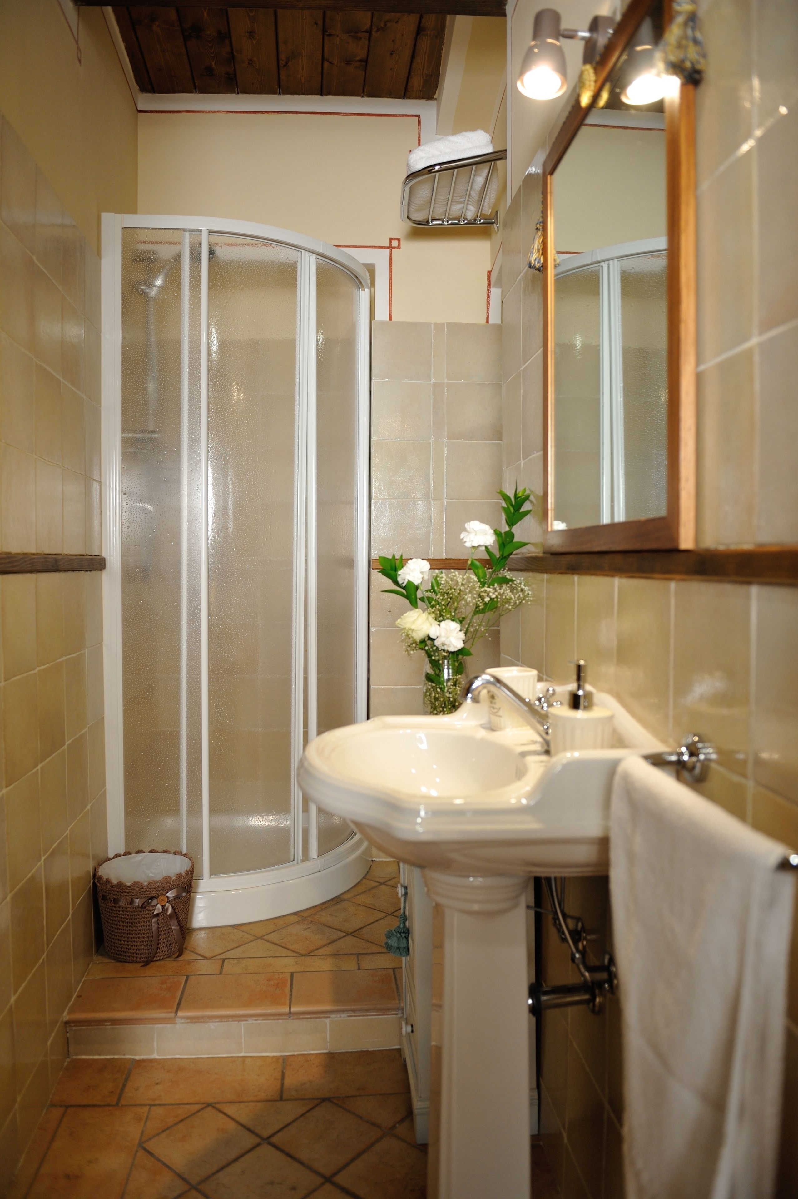Ein Badezimmer mit Dusche, Waschbecken und Spiegel.