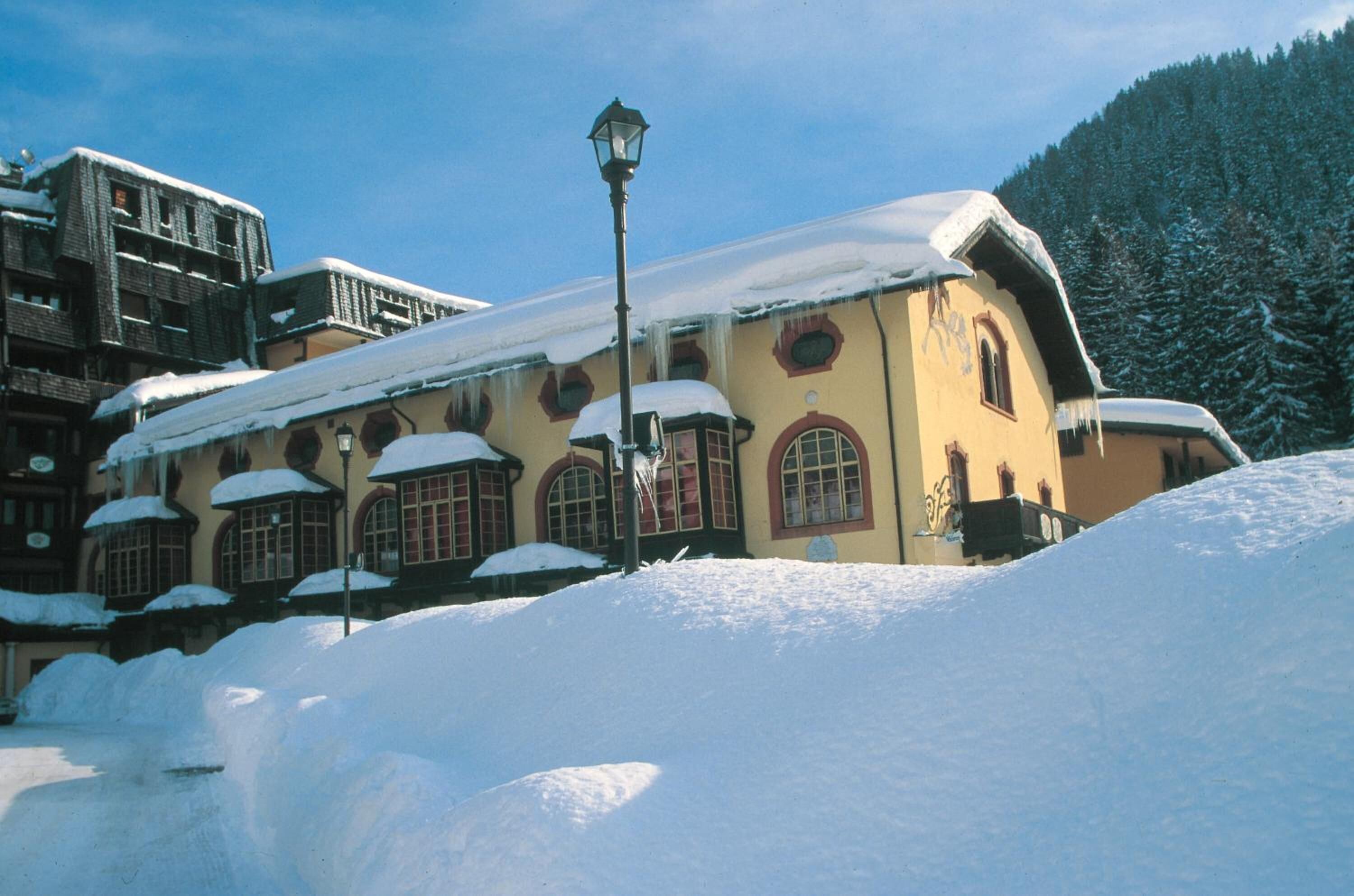 Un edificio cubierto de nieve con ventanas arqueadas y un farol en frente.
