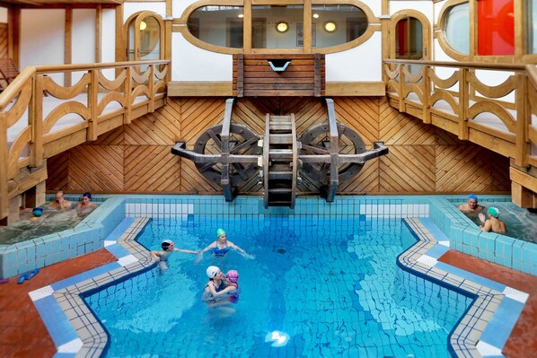 A swimming pool with wooden railings and a wooden floor.