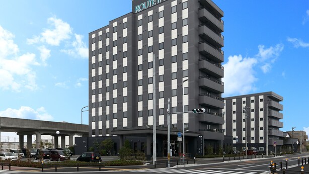 A multi-story hotel with a modern design, featuring a prominent sign at the top. - Hotel Route-Inn Tokoname Ekimae (Tokoname)