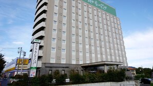 Ein mehrstöckiges Hotel mit Gründach und einem Schild in japanischer Schrift.