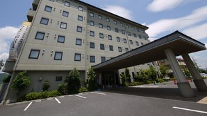 Un hôtel à plusieurs étages, doté d’une façade sobre, d’une entrée abritée et d’un parking.