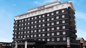 Ein mehrstöckiges Hotel mit einer schwarz-weißen Fassade, zahlreichen Fenstern und einem Schild, das es als Hotel kennzeichnet.