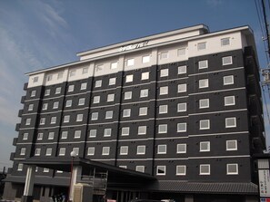 Un hôtel à plusieurs étages, doté d’un design moderne, avec de nombreuses fenêtres et un toit plat.