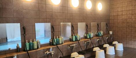 A public restroom with multiple sinks, hand soap dispensers, and paper towel holders.